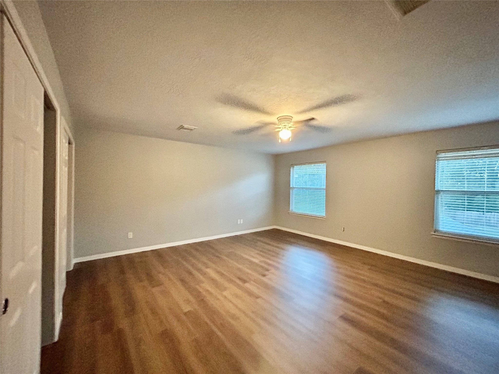 22918 Breton Point Drive Spring, TX 77373 - Photo 43 of 49 an empty room with wooden floor and windows