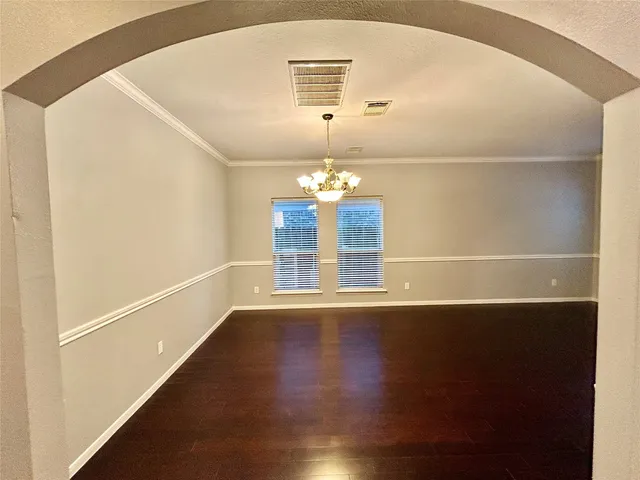a view of a room with wooden floor chandelier and a window