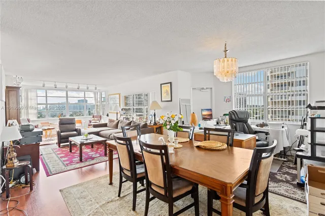 a living room with furniture a large window and a chandelier
