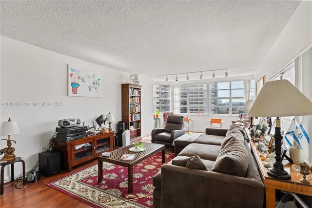 a living room with furniture and floor to ceiling windows