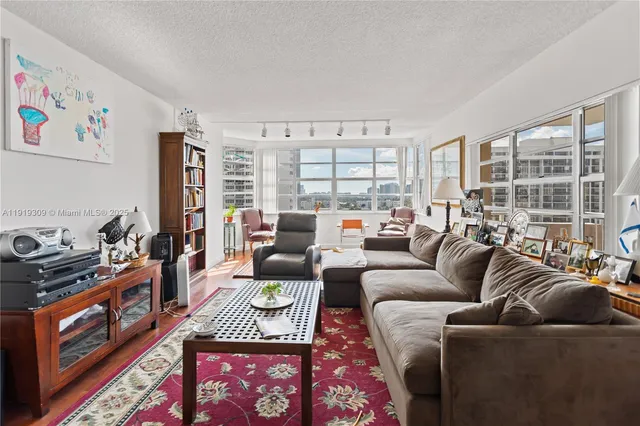 a living room with furniture and floor to ceiling windows
