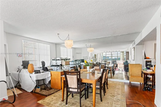 a kitchen with stainless steel appliances a sink a stove a refrigerator cabinets and dining table