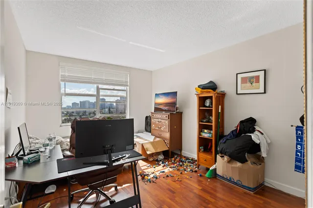 a bedroom with a bed and a flat tv screen on dresser