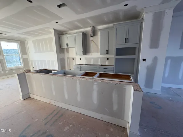 a kitchen with stainless steel appliances a white refrigerator a sink a stove a microwave a counter top and white cabinets