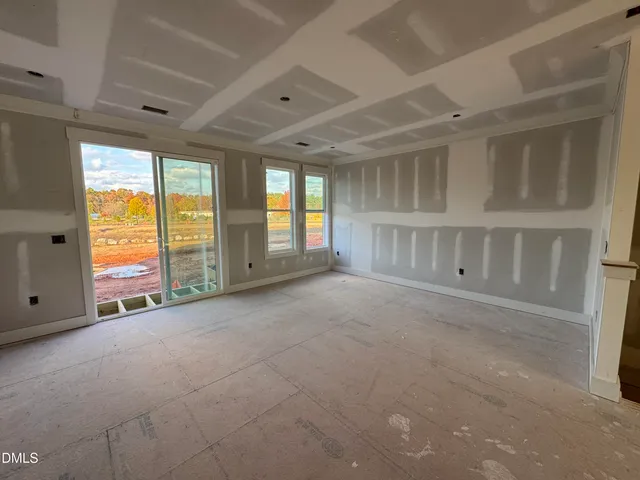 a view of an empty room with a fireplace and a window