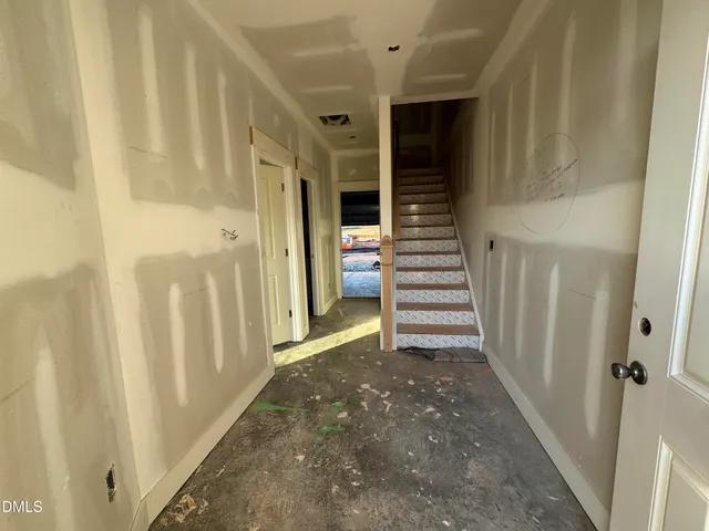 a view of a hallway with stairs and furniture
