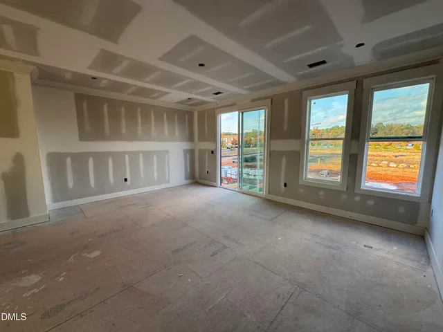 a view of empty room with a kitchen