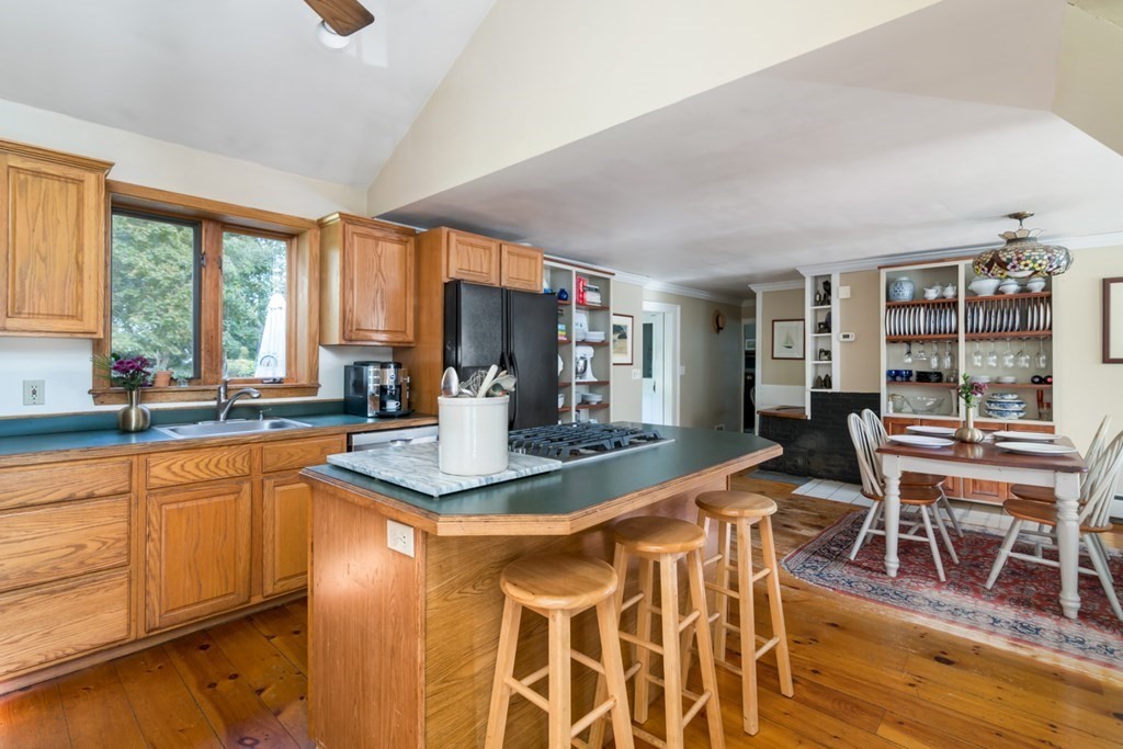 887 Broadway Hanover, MA 02339 - Photo 3 of 27 a kitchen with stainless steel appliances granite countertop sink microwave and wooden floor