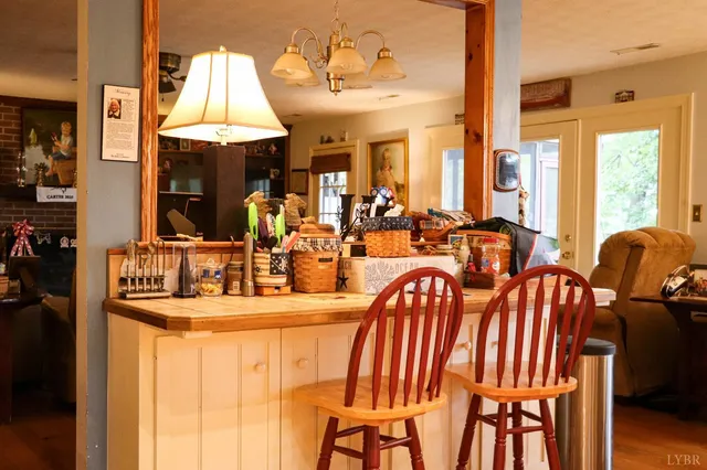 a dining room with furniture a chandelier and a flat screen tv