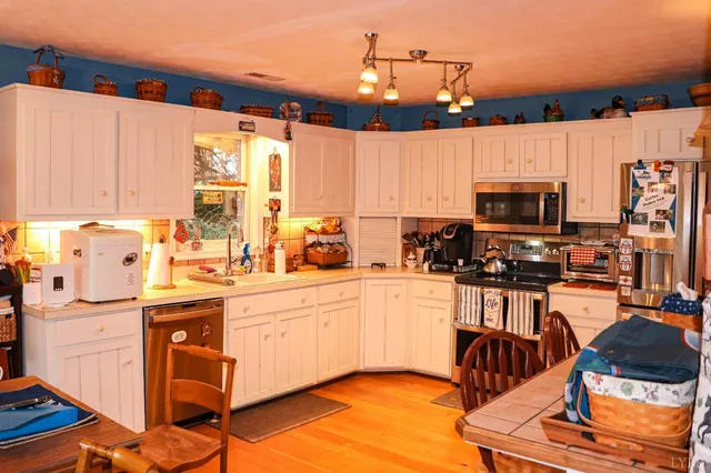 a kitchen with stainless steel appliances kitchen island granite countertop a sink and cabinets