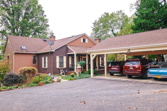 a view of a house with a cars park side of a road