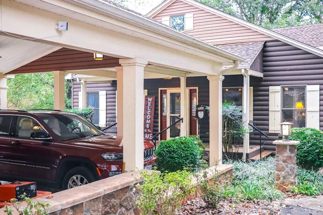 a brick house with a yard potted plants and table chair
