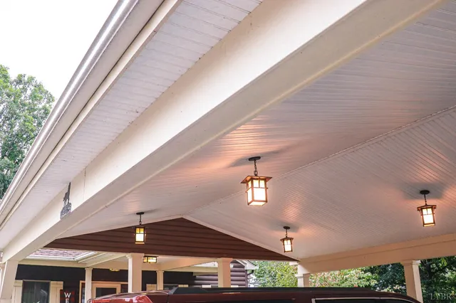 a view of a brick house with a small yard and a large tree