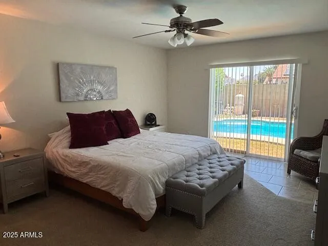a bedroom with a bed couch and large window