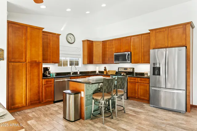 a kitchen with stainless steel appliances granite countertop a stove a refrigerator a sink dishwasher with a dining table and chairs