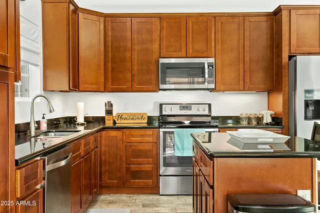 a kitchen with stainless steel appliances granite countertop a stove a sink and a microwave