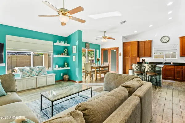 a living room with furniture ceiling fan and a window