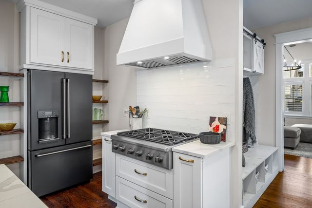 a living room with furniture a flat screen tv and a floor to ceiling window