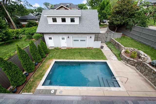 an aerial view of residential houses with outdoor space and trees