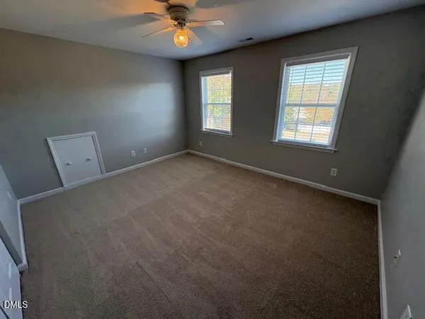 an empty room with a ceiling fan and a window