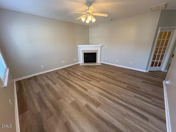 a view of an empty room with a chandelier fan