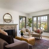 a living room with furniture a fireplace and a floor to ceiling window