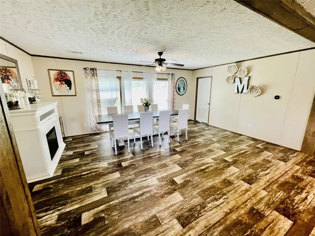 a dining room with wooden floor and white walls