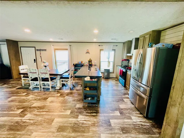 a living room with furniture a large window and kitchen view