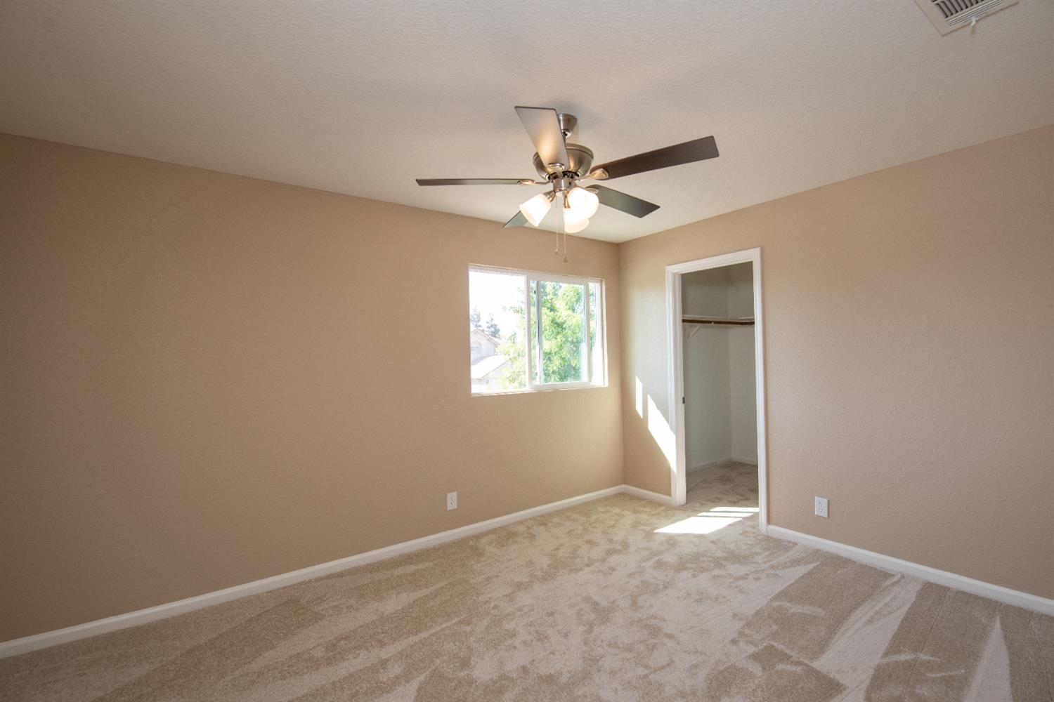 1621 Davis Street Ripon, CA 95366 - Photo 28 of 43 unfurnished bedroom featuring carpet, ceiling fan, and a spacious closet