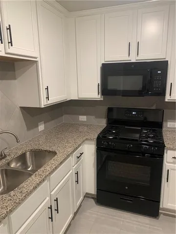 a kitchen with granite countertop a stove and a sink