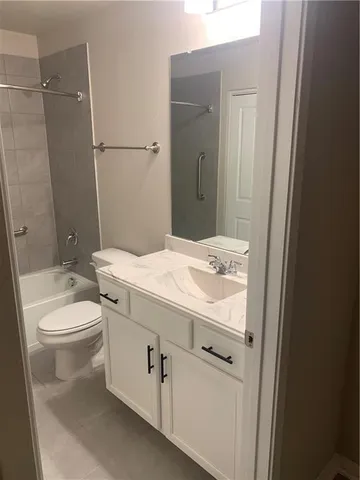 a bathroom with a granite countertop toilet sink and mirror