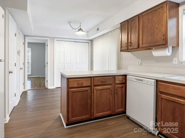 a kitchen with stainless steel appliances granite countertop wooden cabinets a sink and dishwasher