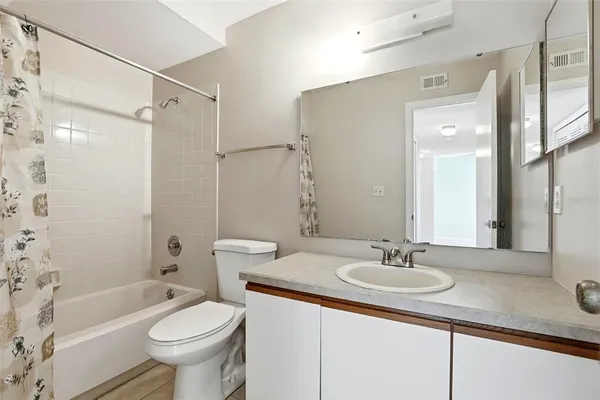 a bathroom with a sink toilet vanity and shower