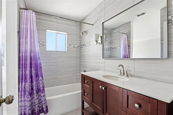 a bathroom with a sink a mirror a vanity and a bathtub