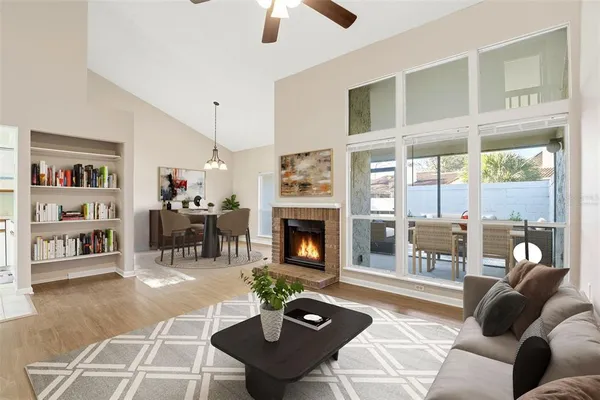 a living room with furniture a fireplace and a floor to ceiling window