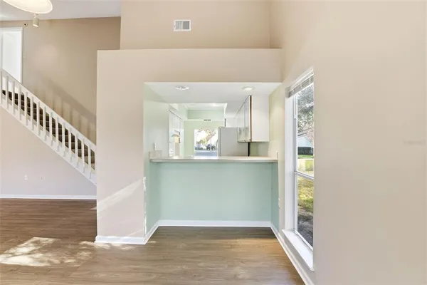 a view of a hallway with wooden floor and staircase