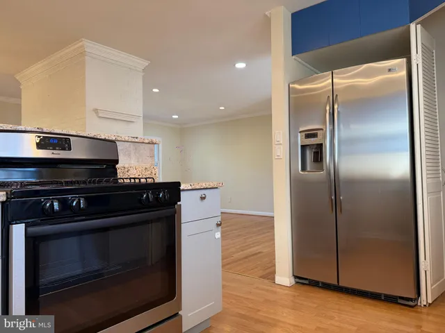 a kitchen with granite countertop a stove and a refrigerator