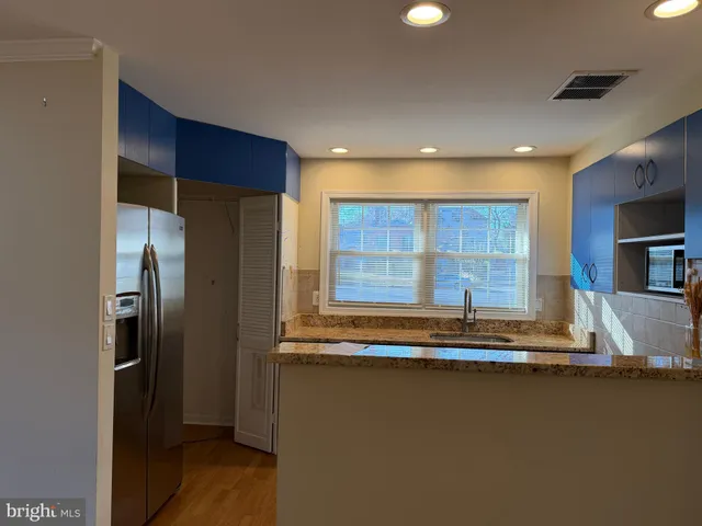 a kitchen with stainless steel appliances granite countertop a refrigerator and a sink