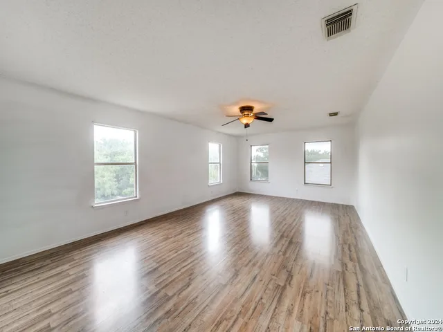 a view of a livingroom with wooden floor and a ceiling fan