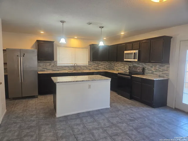 a kitchen with a sink a counter space and a window