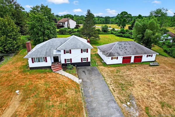 a aerial view of a house next to a yard with large trees