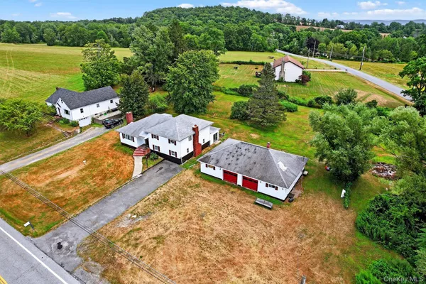 an aerial view of a house with a garden and lake view