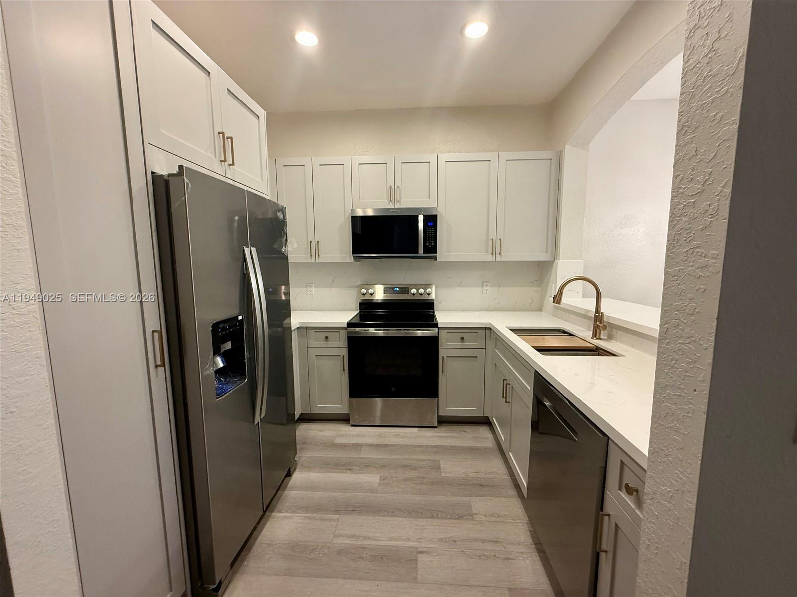 2511 Southwest 99th Way, Unit 2511 Miramar, FL 33025 - Photo 2 of 23 a kitchen with granite countertop a refrigerator and a stove
