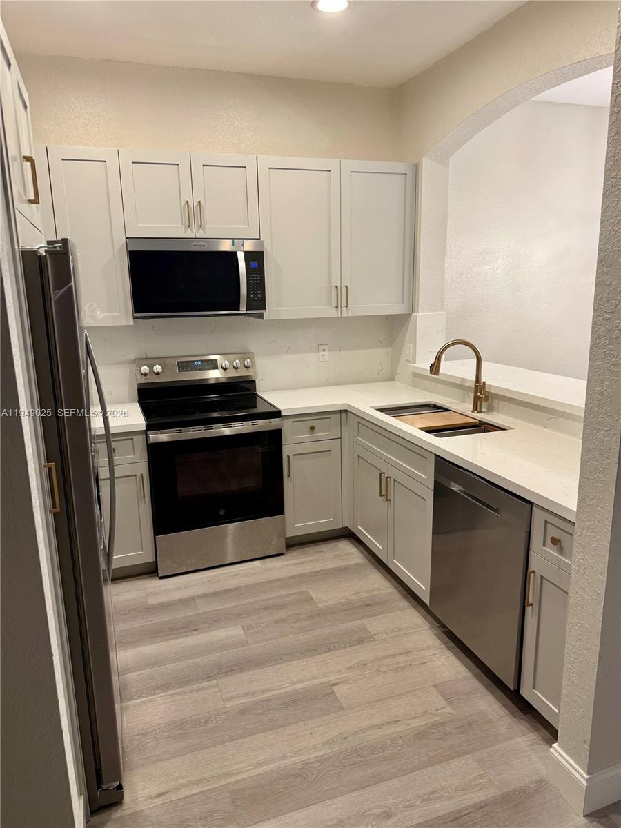 2511 Southwest 99th Way, Unit 2511 Miramar, FL 33025 - Photo 5 of 23 a kitchen with a sink stove and refrigerator