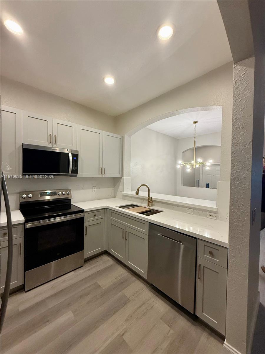 2511 Southwest 99th Way, Unit 2511 Miramar, FL 33025 - Photo 6 of 23 a kitchen with sink a microwave and cabinets