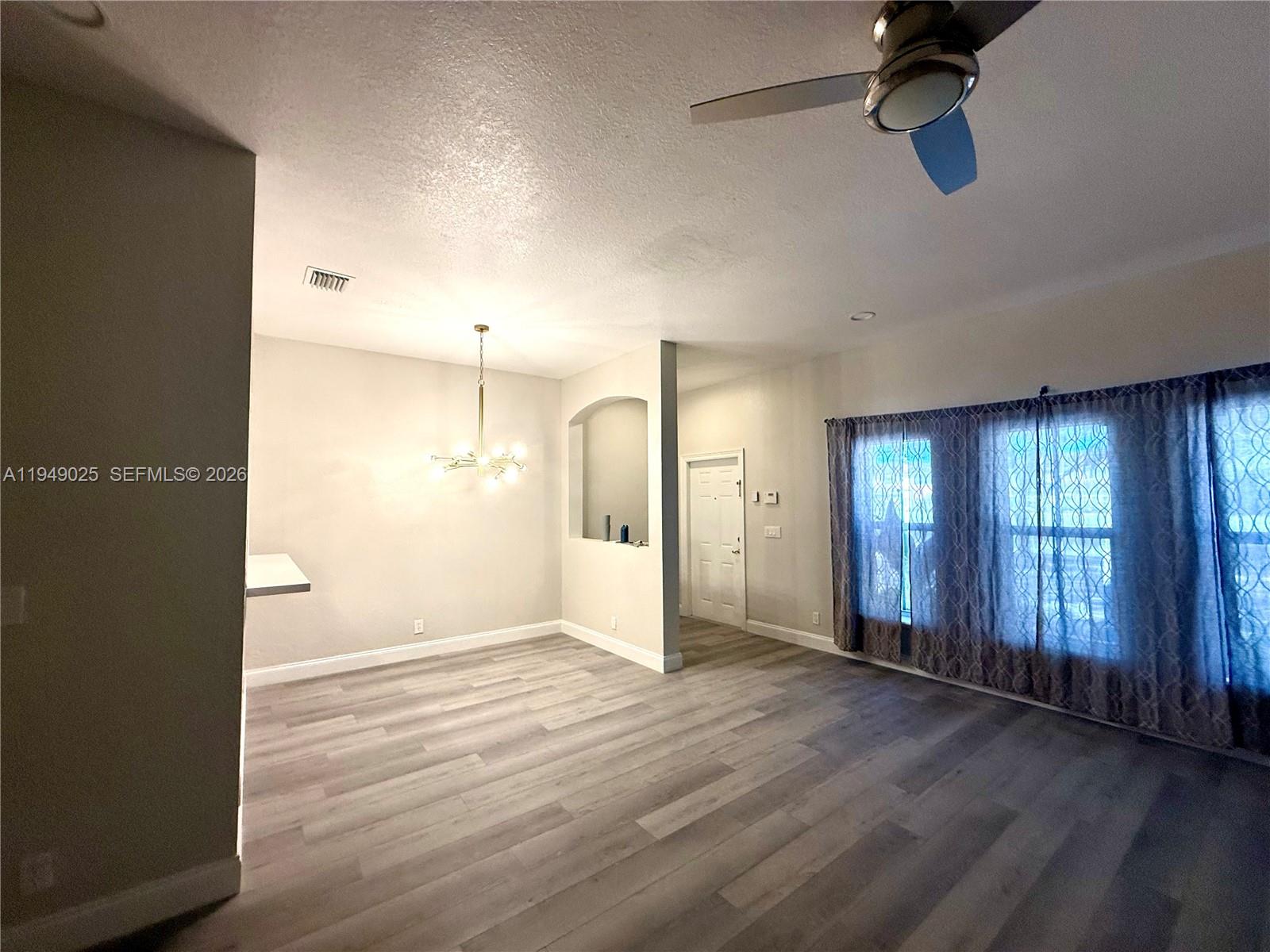 2511 Southwest 99th Way, Unit 2511 Miramar, FL 33025 - Photo 10 of 23 an empty room with wooden floor and windows