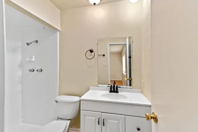 a bathroom with a sink toilet and mirror