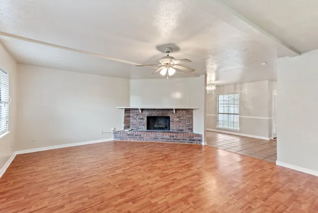 a view of an empty room with a fireplace and a window