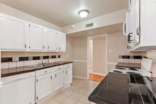 a kitchen with white cabinets and white appliances