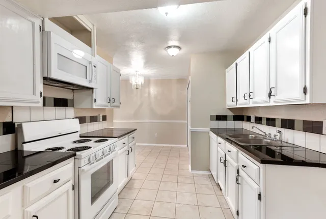 a kitchen with stainless steel appliances granite countertop a sink and cabinets
